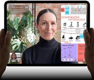 iPad Pro, front exterior, landscape orientation, space black colour, rounded corners, black display bezel, hands holding left and right sides, display showing a FaceTime conversation being live translated, and an educational app showing a presentation of "Comparative Mythology" with text, diagrams and handwritten notes