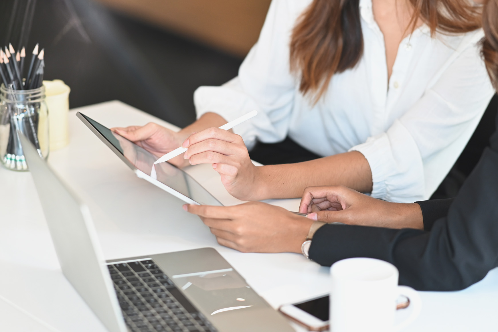 two business women working together on a tablet