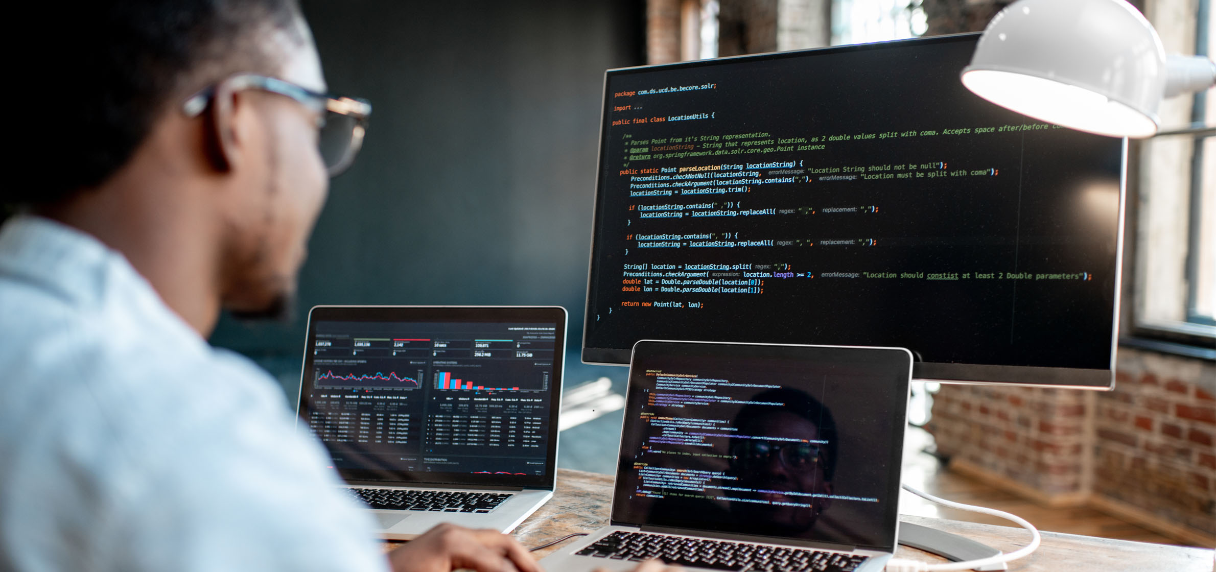 man working on several computer screens