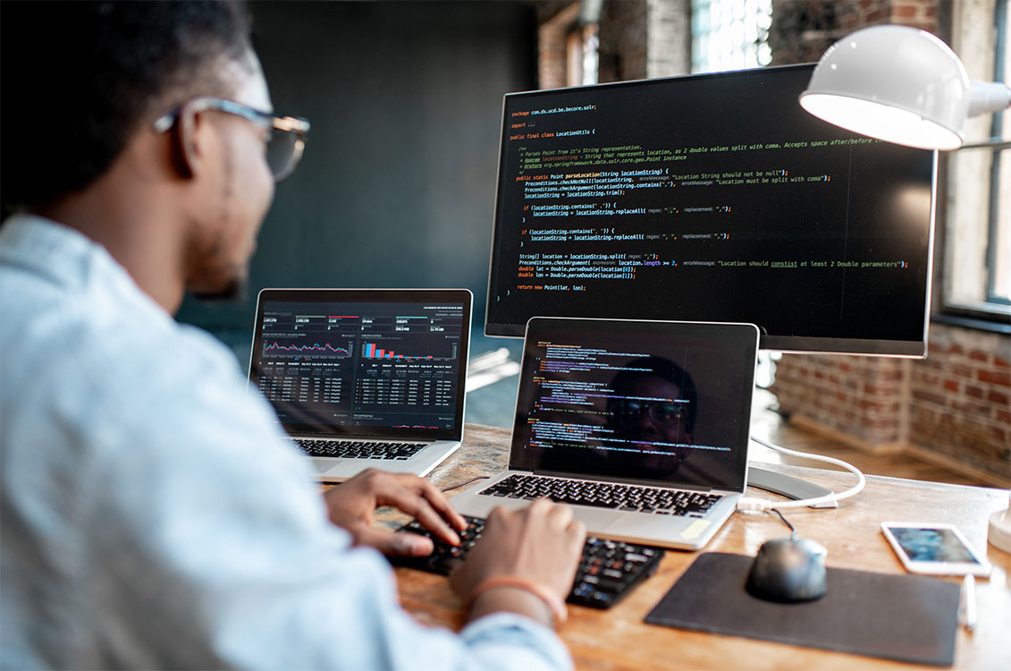 Man working on multiple computer screens