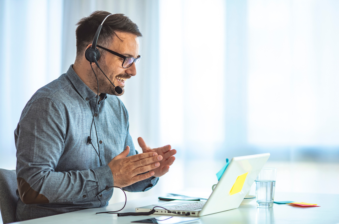 workers at computer one with a headset on