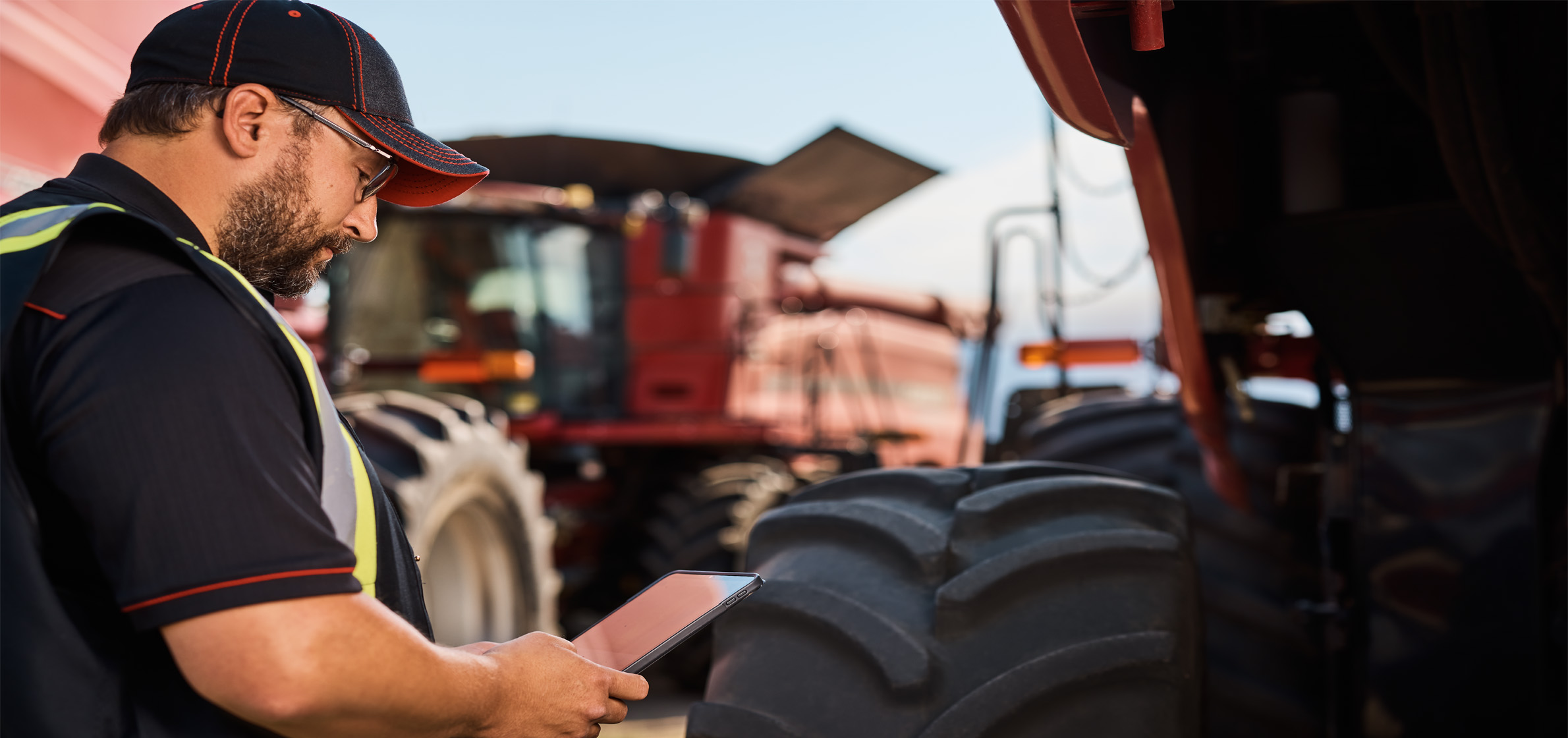 Man on ipad in front of tractor