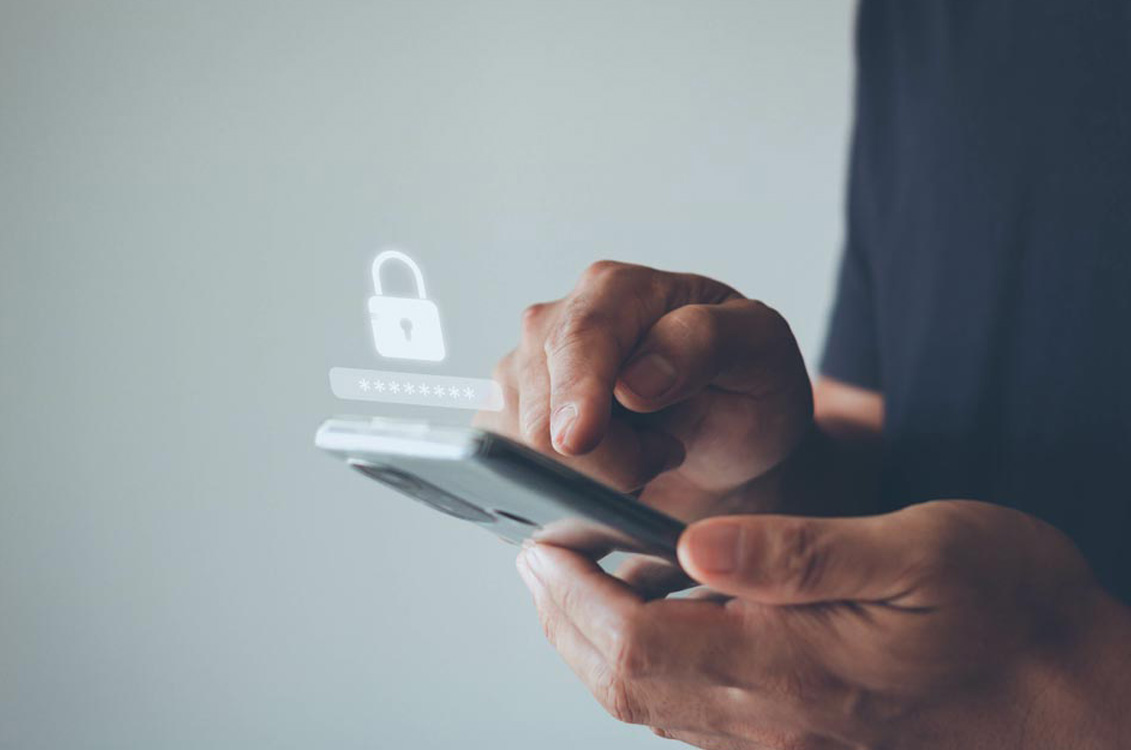 Person typing on cellphone; lock icon and password indicate the device is locked