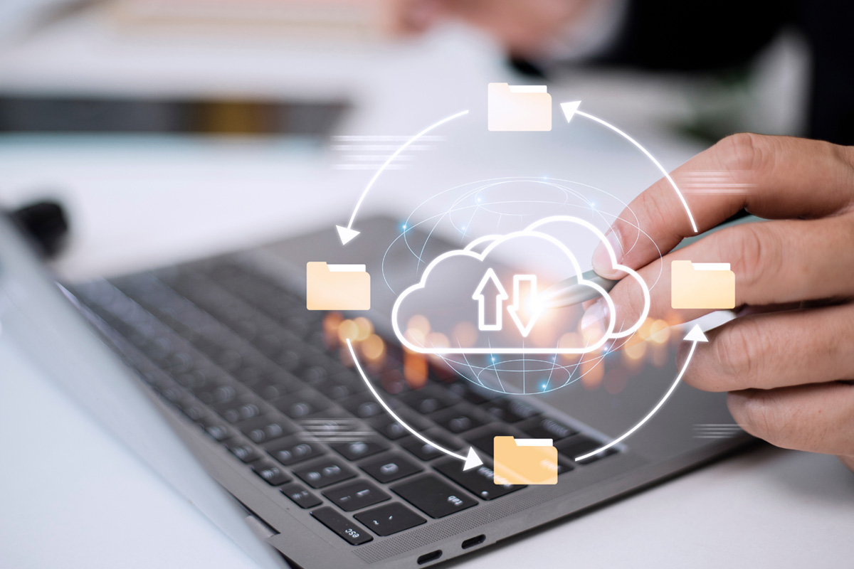 person on laptop with cloud graphic overlaid