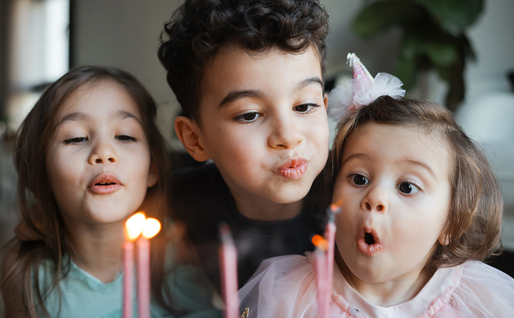 Kids blowing out candles