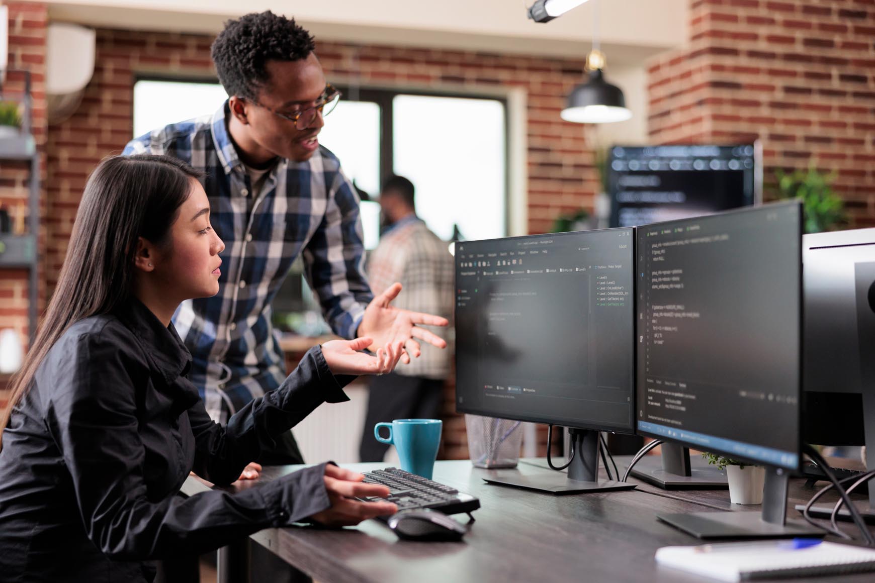 two employees working together on the same computer