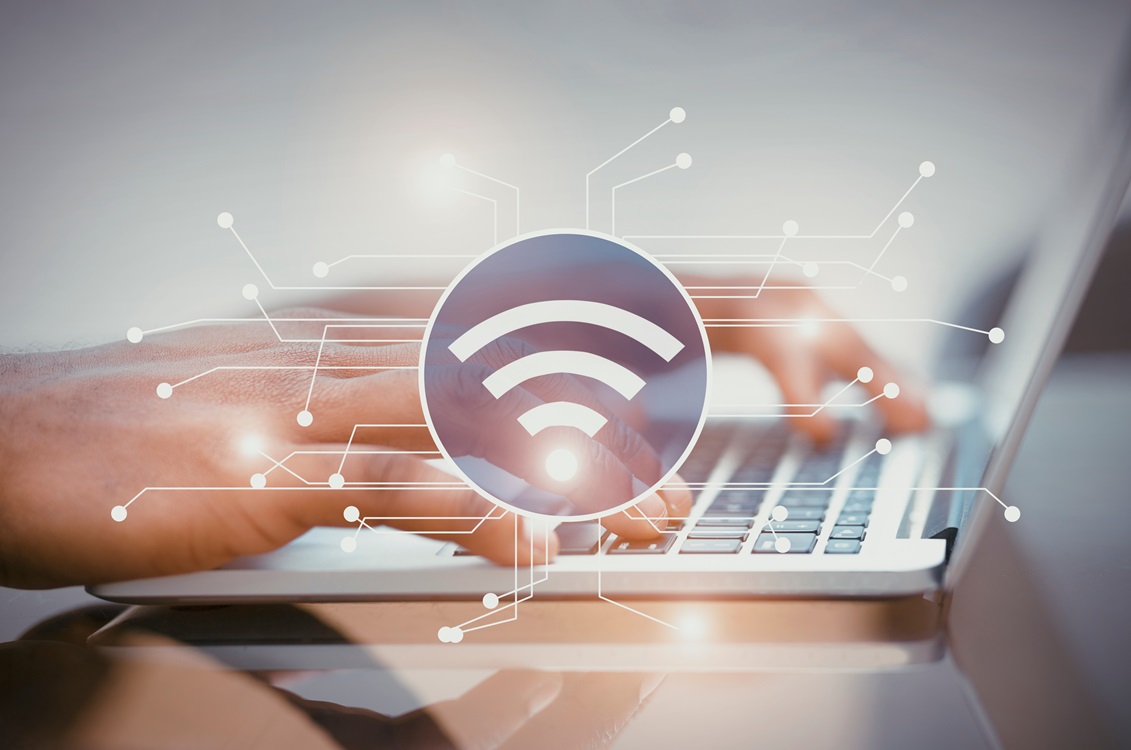 typing on laptop with wi-fi symbol in forefront