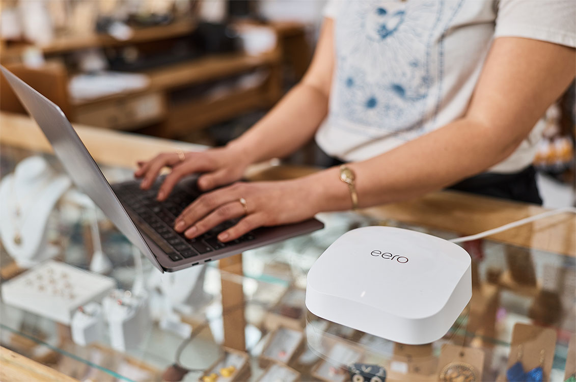 typing on laptop with wi-fi symbol in forefront