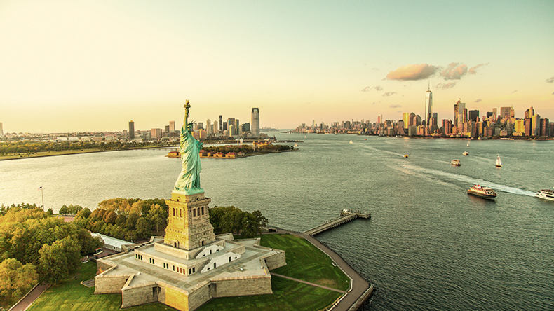 an aerial view of the Statue of Liberty overlooking the water with the city in the background an aerial view of the Statue of Liberty overlooking the water with the city in the background